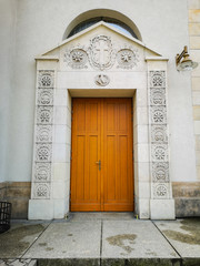 Huge wooden doors with white reliefs to cathedral