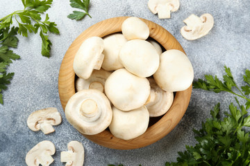 Bunch of farm raised organic mushrooms laid in composition on textured background. Champignons on table counter. Clean eating concept. Background, close up, flat lay, top view.