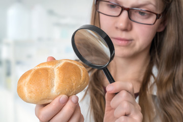 Scientist examines a bun with magnifying glass