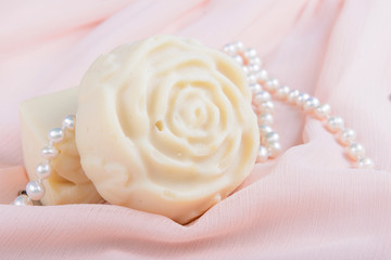 handmade soap in the shape of a rose on a pink cloth