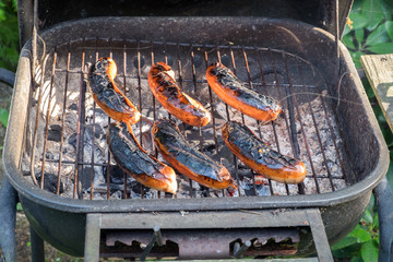 Hot dogs to be burned on a barbecue stove.
