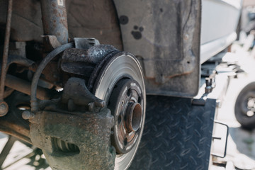 change the old drive to the Brand new brake disc on car in a garage. Auto mechanic repairing .