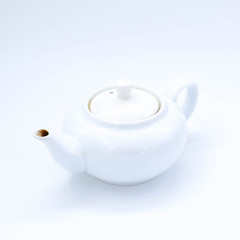 cup with tea and teapot on white background, over light
