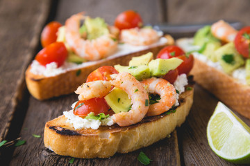 Sandwich with vegetables and prawns. Bruschetta with avocado and shrimp