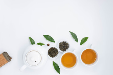 cup with tea and teapot on white background, over light
