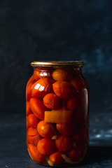 glass jars of fermented tomato, onion, chili pepper, spices, salt. vegetables on a dark background. Probiotic Source A popular vegetarian food. copy space