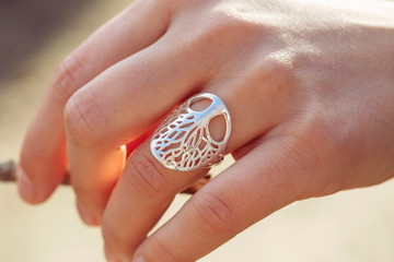 Female hand wearing beautiful silver ring in the shape of the tree