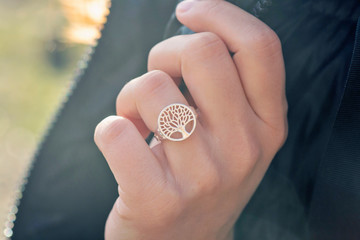 Female hand wearing beautiful silver ring in the shape of the tree