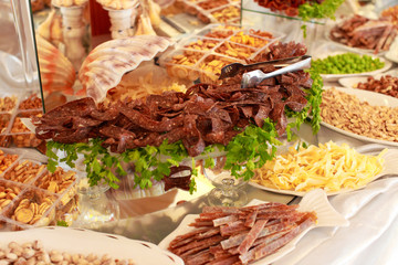 Beautifully decorated catering banquet table with profiteroles, salads and cold snacks. Variety of tasty delicious snacks on the table. Wedding table serving. Meat and vegetables