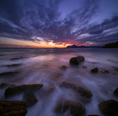Obraz premium Seascape with a very beautiful picturesque sky at sunset and mountains