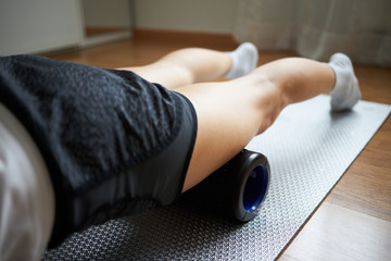 Fototapeta premium Woman body massaging herself with a massage roller. No face