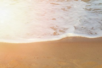 Soft focus of the waves beat at the beach with shell fragments with sunlight in summer time. Nature background concept.