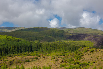 Hills over fields. Terceira island in Azores with blue sky and clouds.