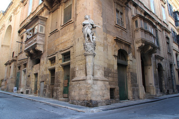 Fototapeta na wymiar statue of holy character, streets and houses in valletta (malta)