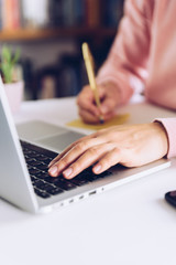 Woman hands writing a note on a white marble desk.