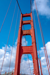 Fototapeta premium Close up of single tower of Golden Gate Bridge in white clouds San Francisco, USA, bottom view