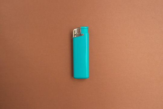  Blue Lighter With A Button On A Brown And White Background. Top View. Mock Up. Flat Lay Composition