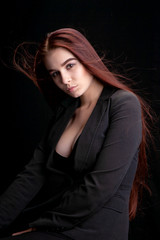 Fototapeta premium young woman in studio on a black background with flying hair