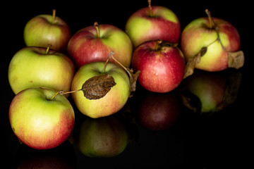 Lot of whole fresh garden apple isolated on black glass