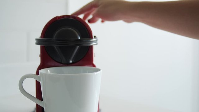 Slow motion 60/24p close-up on a woman's hand brewing coffee in a white kichen