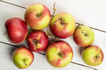 Lot of whole fresh garden apple on white wood