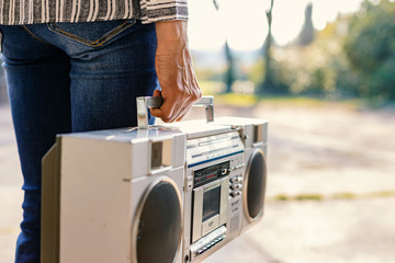 A woman holding a boombox. This retro style radio was very popular in the eighties, and people...