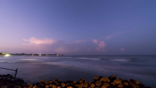Starry sunrise time lapse video, from dark to first morning light, during thunder and lightning storm on beach with waves in Nicaragua