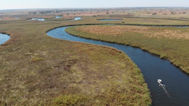Aerial View Of Boat Riding On The Beautiful Okavango Delta River In Botswana - Aerial Drone Shot