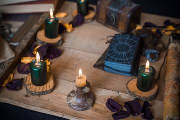 Fototapeta na wymiar Tarot cards and other magic attributes for rituals and fate prediction, details on a table of witch, occultism concept