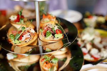 Wedding dinner table service. Wooden dishes with sliced meat and cheese with other snacks stand on a table
