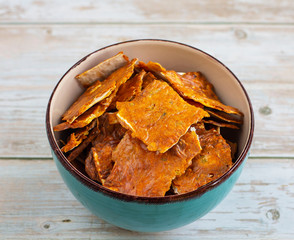 Homemade pita chips with sauce, herbs and cheese