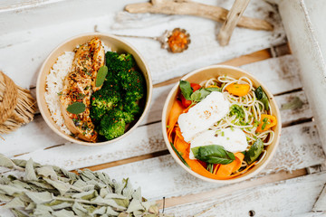 Various healthy and vitamin-rich dishes and food in an ecobox delivered by a delivery service, ordered online, decorated with bundles of straw, mussels and cacti, in a Mediterranean style