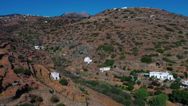 Aerial shot of a classic cycladic landscape, on the Greek island of Sifnos. Camera flies through a gorge.