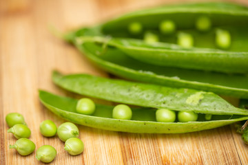 macro view of green peas and pods on a cutting board. Selective focus