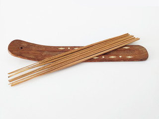 Aerial view of natural incense sticks on rectangular wooden censer isolated on white background.