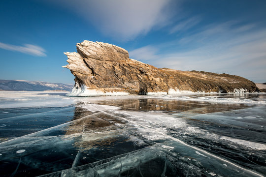 Ogoy island on lake Baikal in winter, transparent ice with cracks