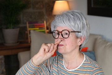 Senior woman picking her nose