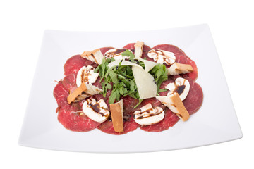 Carpaccio meat with parmesan cheese and arugula.