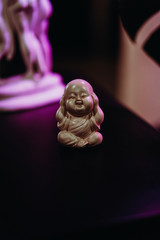 small buddha figurine under neon lighting