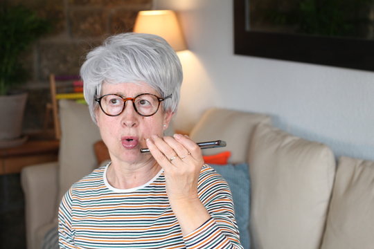 Senior woman talking to smartphone app