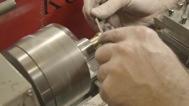 Jeweler, goldsmith in a professional jewelry workshop files down a gold ring 