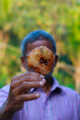 Man with Indian Food know as "Vada"