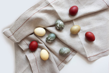 Rustic background. Colored eggs on a woven fabric. Easter