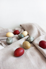 Rustic background. Colored eggs on a woven fabric. Easter