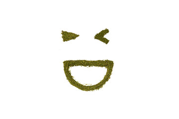 Obraz premium Laughing smiling face wink from grinded marijuana on white background