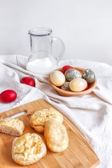 Rustic background. Easter. Colored eggs, milk and homemade bakery products