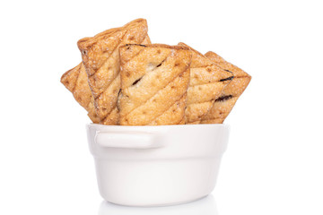 Lot of whole square puff cookie with raisins in porcelain bowl isolated on white