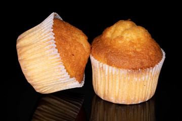 Group of two whole small baked muffin isolated on black glass