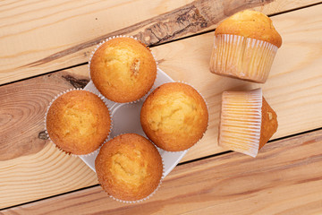 Group of six whole small baked muffin on wood