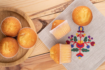 Group of six whole small baked muffin on linen on wood